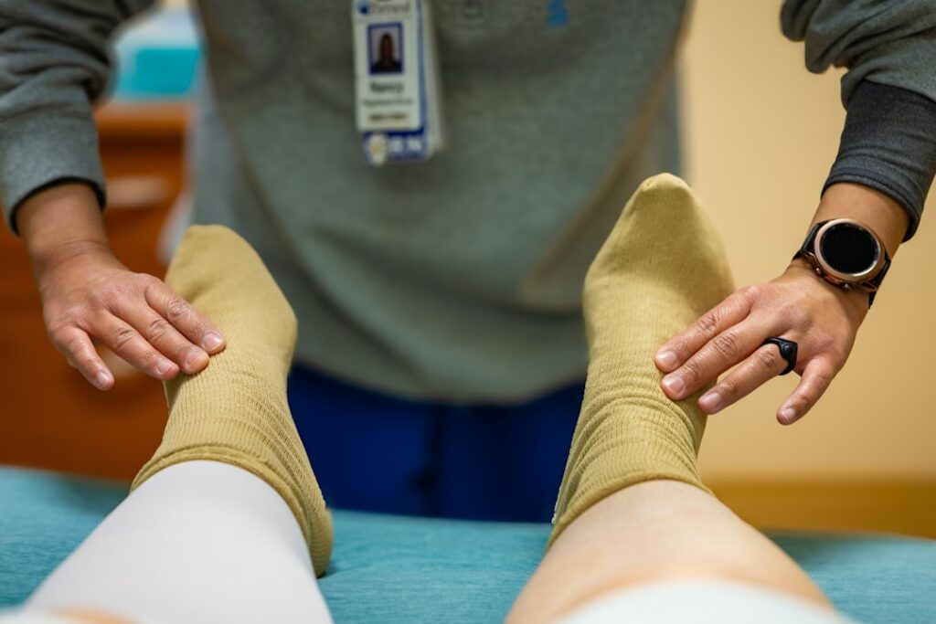 A healthcare worker examines a patients feet.